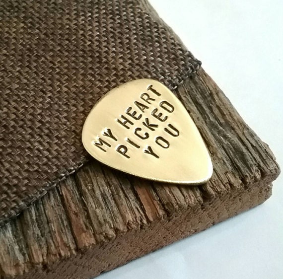 Gold guitar pick with black engraving that said My heart picked you. 