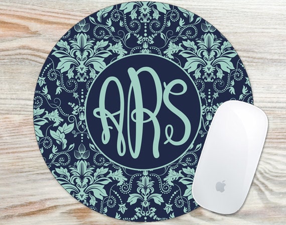 Round dark blue mouse pad with light blue floral patterns around it and ARS in the middle. 