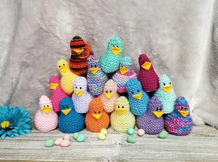 Crocheted chicks all various colors shown all piled on top of each other.  
