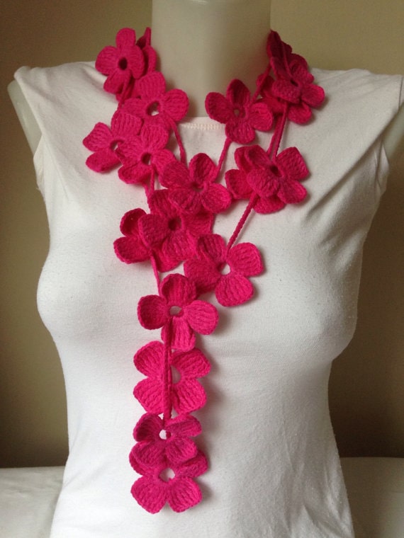 Mannequin with a white tank top with a crocheted pink flowered scarf. 