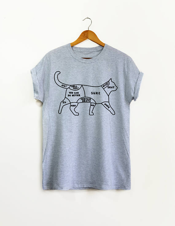 Gifts for the First Time Cat Owner: Light grey t-shirt on a wooden ganger with a drawing of a cat and areas you can pat them. 