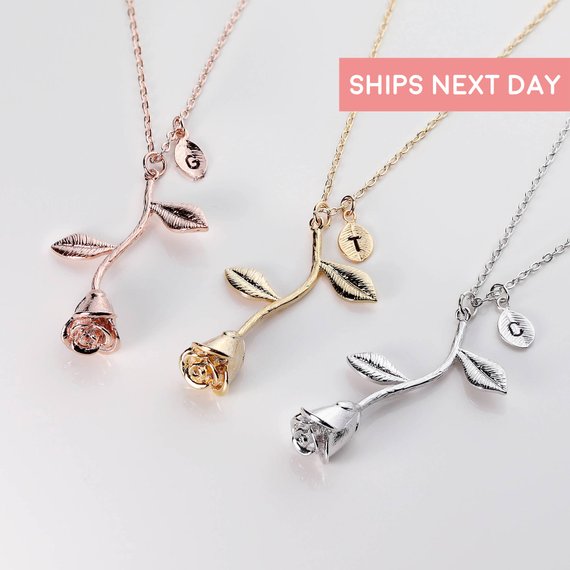 Three rose charm and chain necklaces shown one rose gold. one gold, and lastly silver.