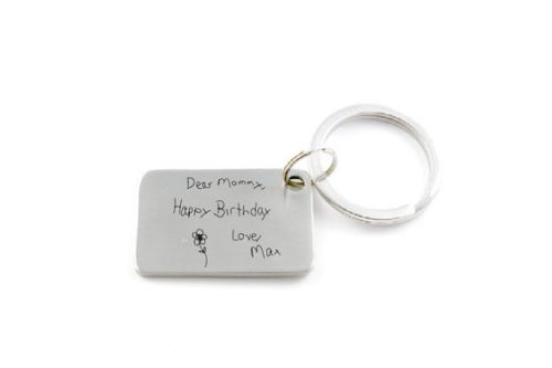 Rectangle keychain with handwritten engraved that says Dear mommy, happy birthday love max with a little flower drawing. 