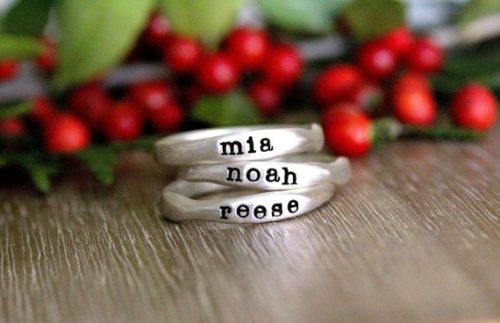 Mother's Day Gifts for a Mom Who Has Everything: Silver stackable name rings with black engraved font that says Mia, Noah, and Reese on the ring. 