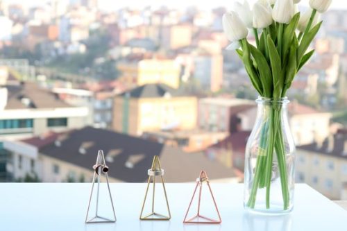 Geometric ring holders shown, three triangle shaped ring holders; silver, gold, and rose gold. 