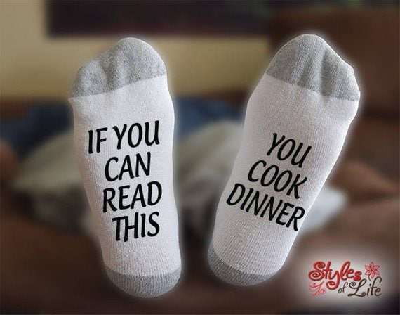 two socks shown, light grey with dark grey ends with black font that says 