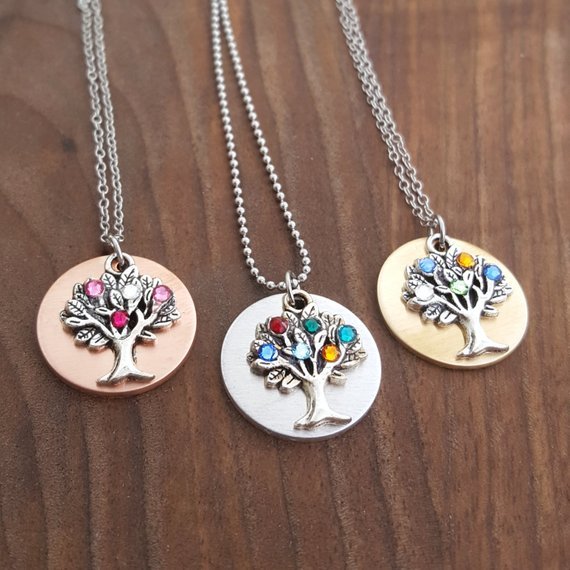 Three silver chained necklaces each with a birthstone tree. 