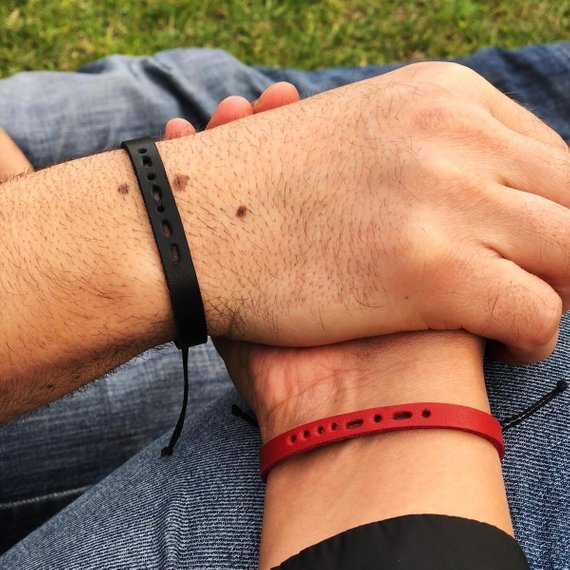 Mother's Day Gifts for Nan: hands being shown holding each other, one with a black morse code leather bracelet and the other with a red morse code leather bracelet. 