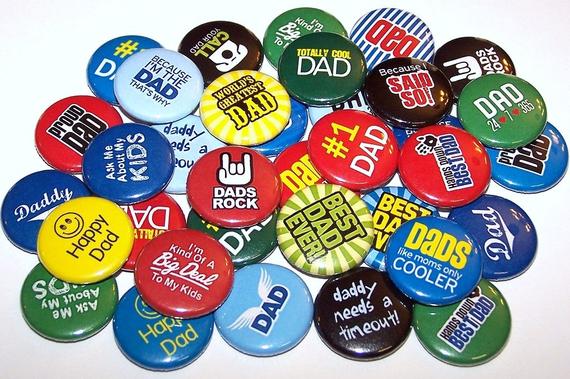 Various buttons with different colors and dad sayings on them. 