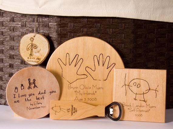 Five different style wood each with an engraved drawing, hands, or message from a child. 