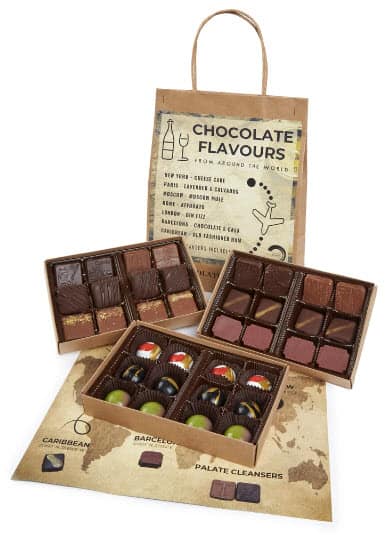 Three boxes of open chocolates with a bag that says chocolate flavors in the background.