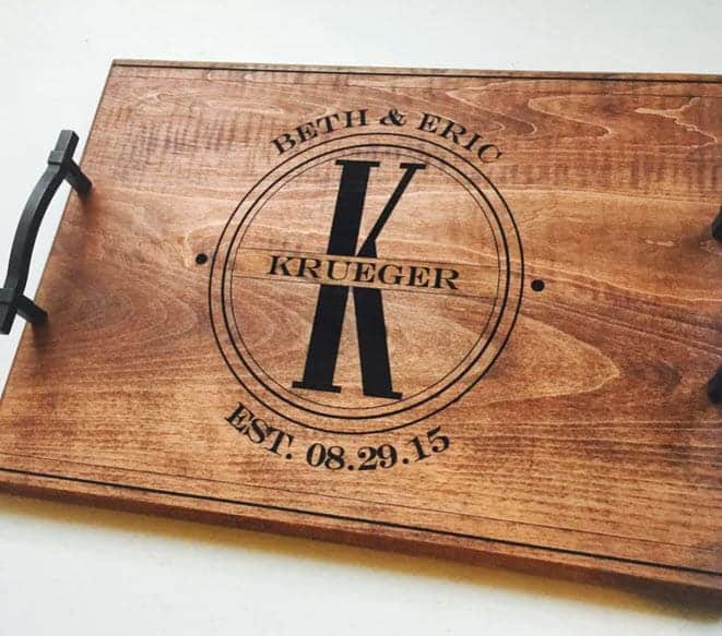 Wooden cutting board with black ink that says Krueger. 