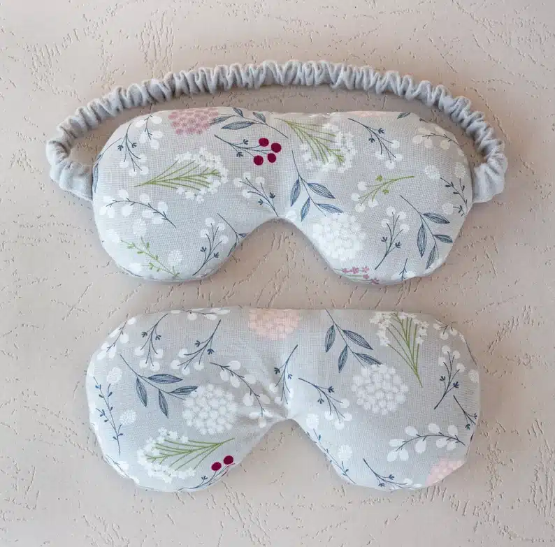 Two floral sleep masks, both light green with flowers on it. 
