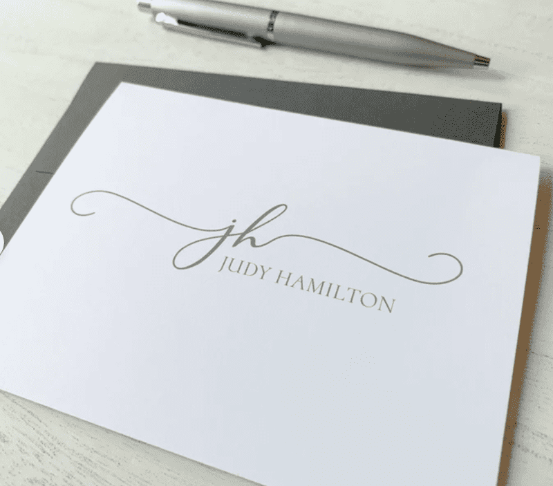 white stationery card that says JUDY HAMILTON in light grey font. 
