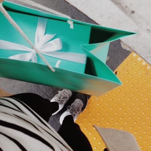A woman holding a shopping bag from Tiffany's store