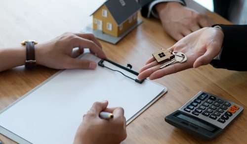 woman holding newly purchased house keys to man
