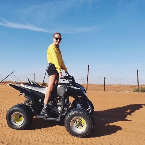 woman standing on a quad in a desert