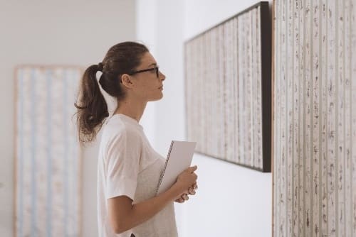 woman looking at a piece of artwork for sale