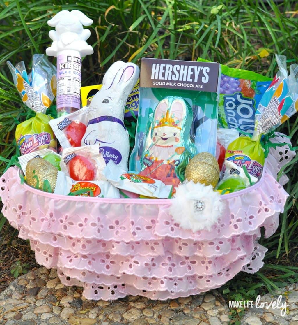 Pink ruffled basket filled with various Easter chocolates and candies. 