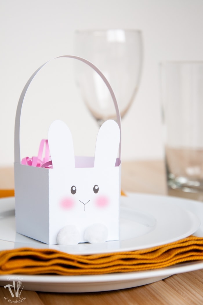 White paper bunny basket with rosy pink cheeks and cotton balls for feet. 