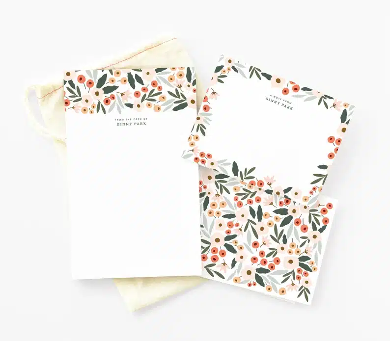 White personalize stationery set with flowers and green leaves all over it. 