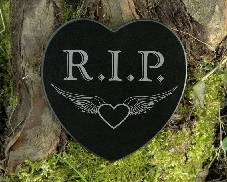Black marble heart shaped plate. That says R.I.P with a heart and wings on it. 