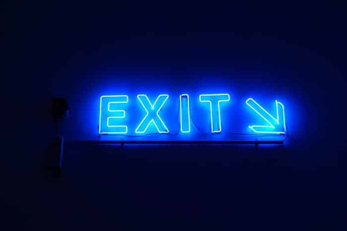 glowing neon blue exit sign with angled arrow