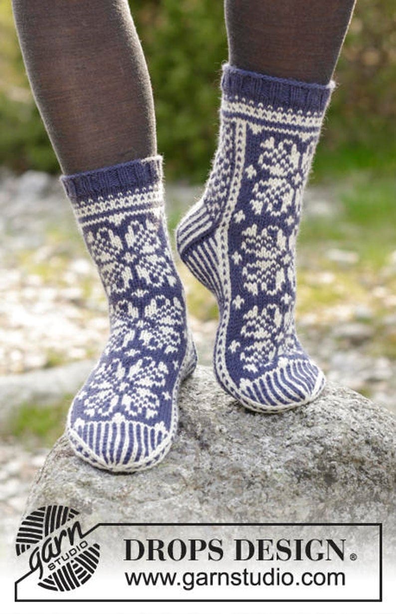 Navy blue knitted socks with white flowered patterns on them. 