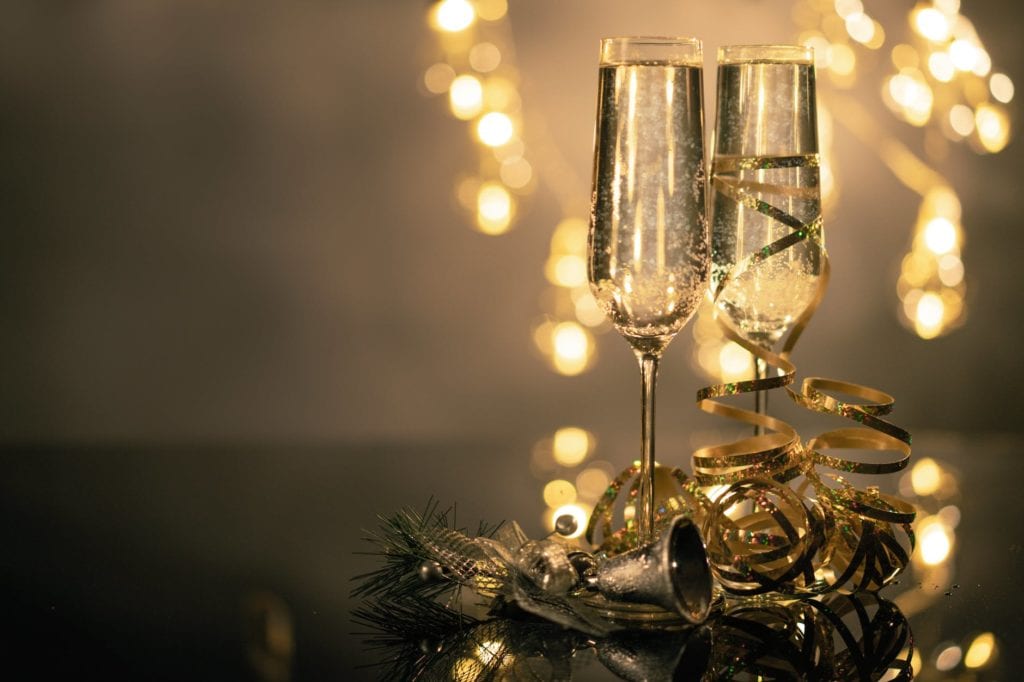 Two champagne glasses on a table lit up