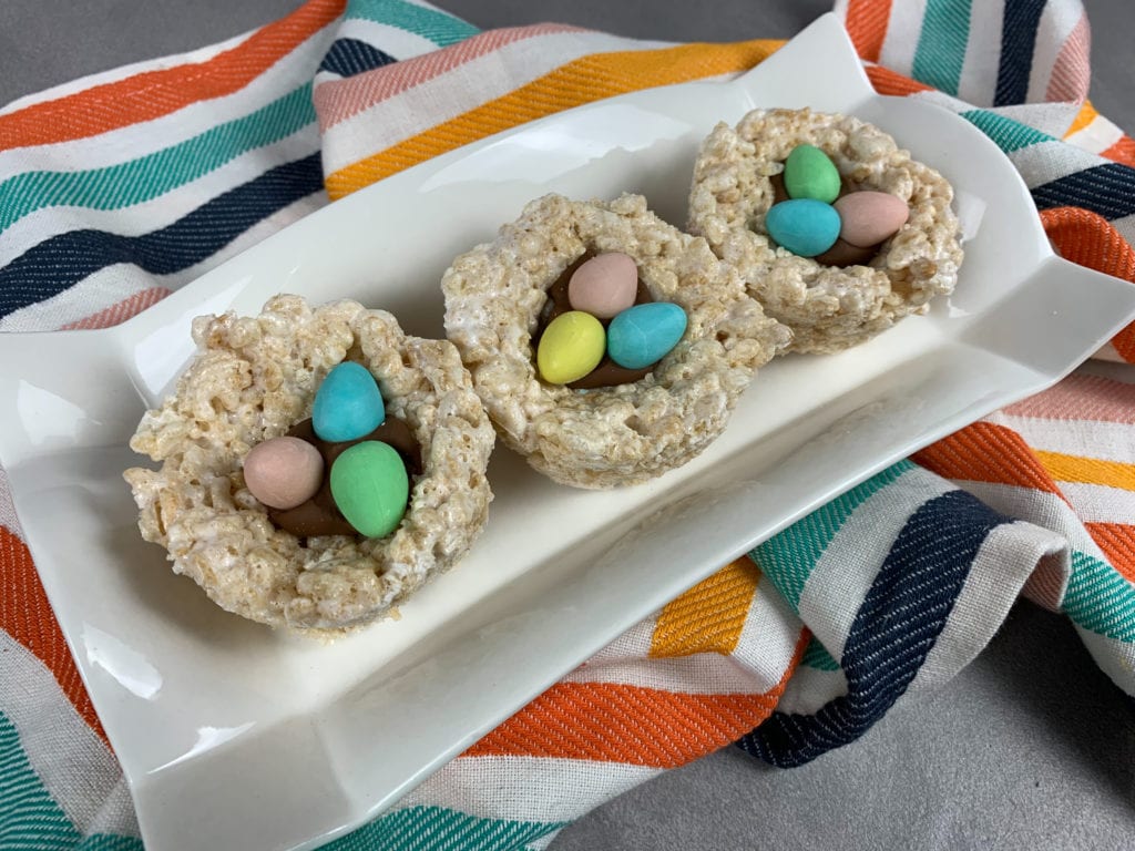 Rectangle white plate with three completed Rice Krispie Easter Egg Nests