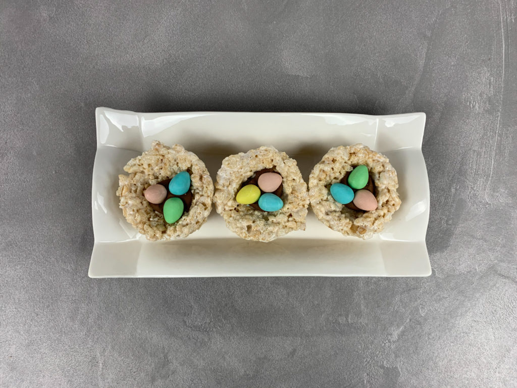 Above view of Easter egg nest treats, each with three mini eggs in the middle. 