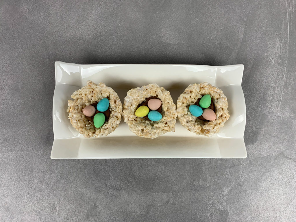 Above view of Easter egg nest treats, each with three mini eggs in the middle.