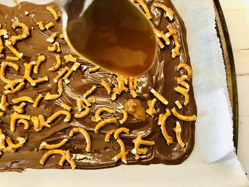 melting caramel over pretzels and chocolate