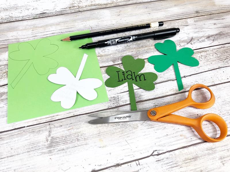 Traced shamrocks, one cut out with Liam written on with black marker. 