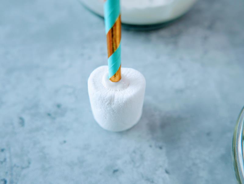 close up of marshmallow with gold and blue straw sticking out of it. 