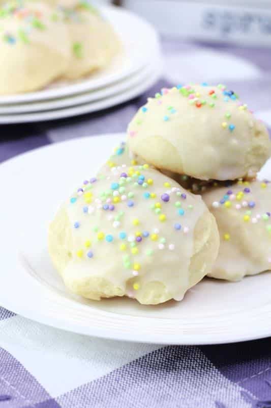 close up of Easter Italian Cookies with white icing and pastel colored sprinkles. 