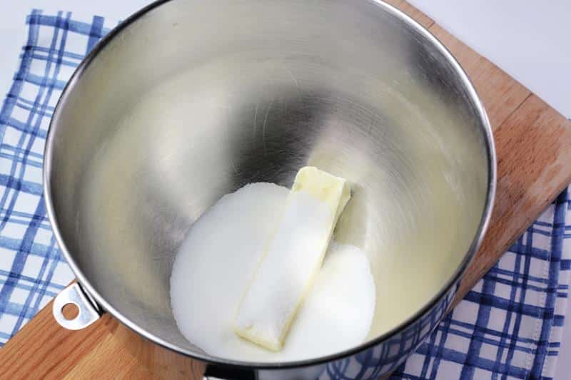 large mixing bowl with sugar and stick of butter in it. 