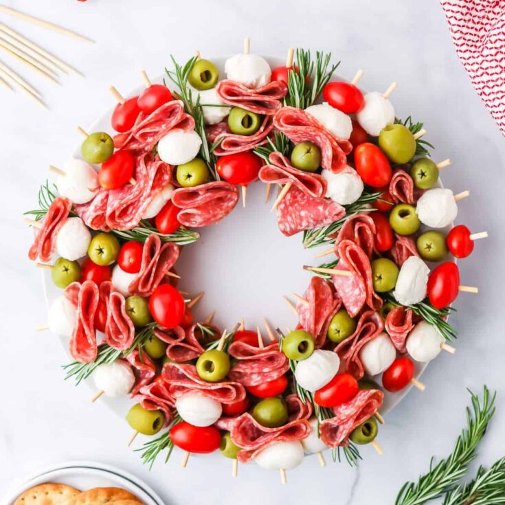 charcuterie wreath made with meat, olives, tomatoes, and cheese wreath