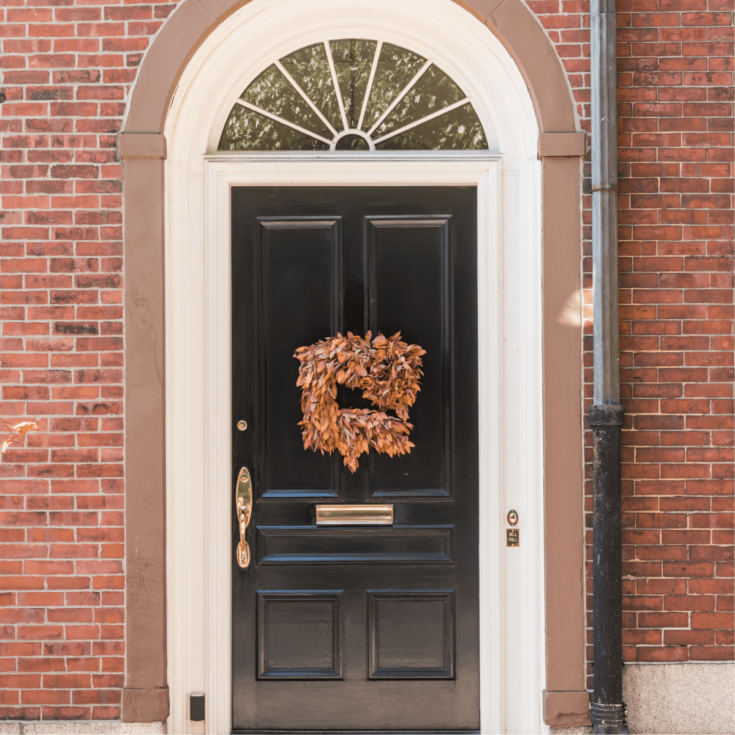 front door with orange wreath on it