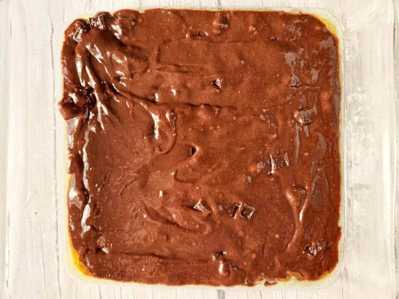 brownie mix spread in a baking tray