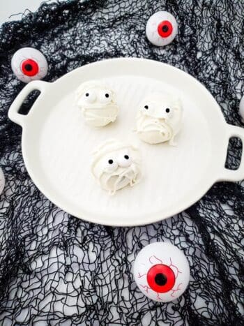 Three completed Mummy Oreo balls on a white plate. 