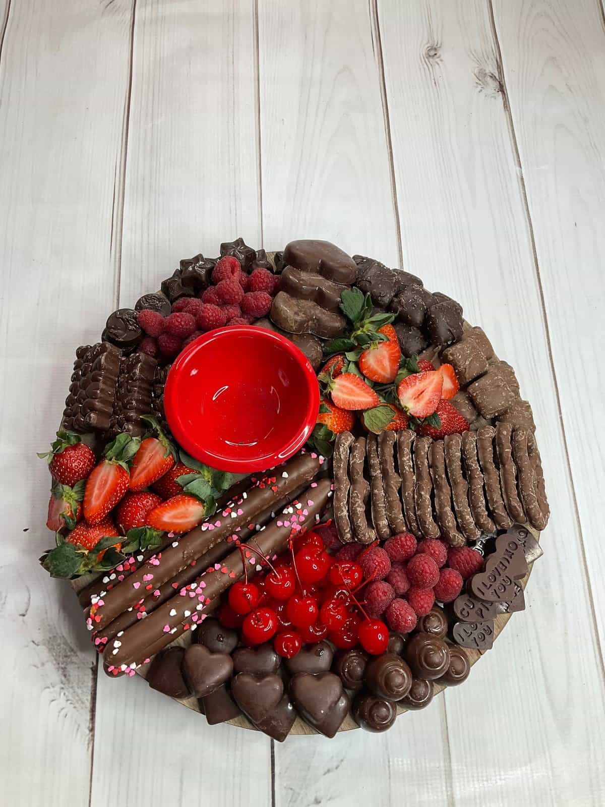 chocolate lovers valentines day board with everything on it but empty red bowl.
