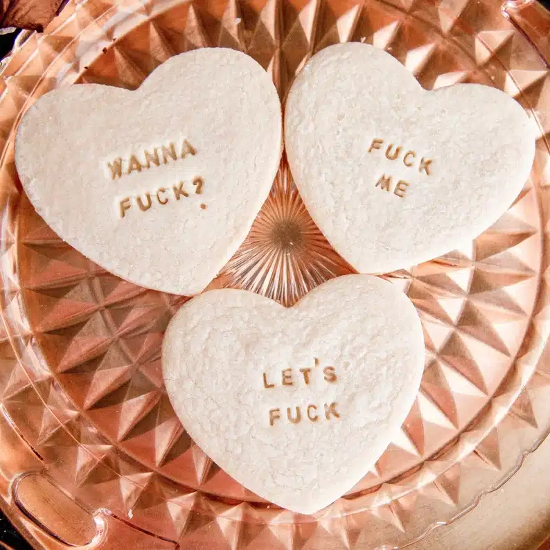 Heart shaped sugar cookies with vulgar sexy messages on them