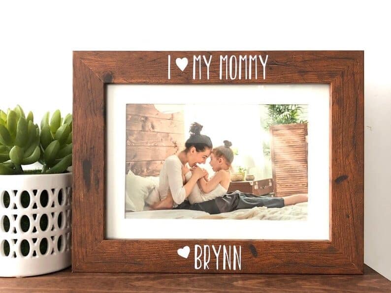 Customized Picture Frame, wooden with white engraving at the top that reads I love my mommy and at the bottom in white font a heart with the name Brynn. 