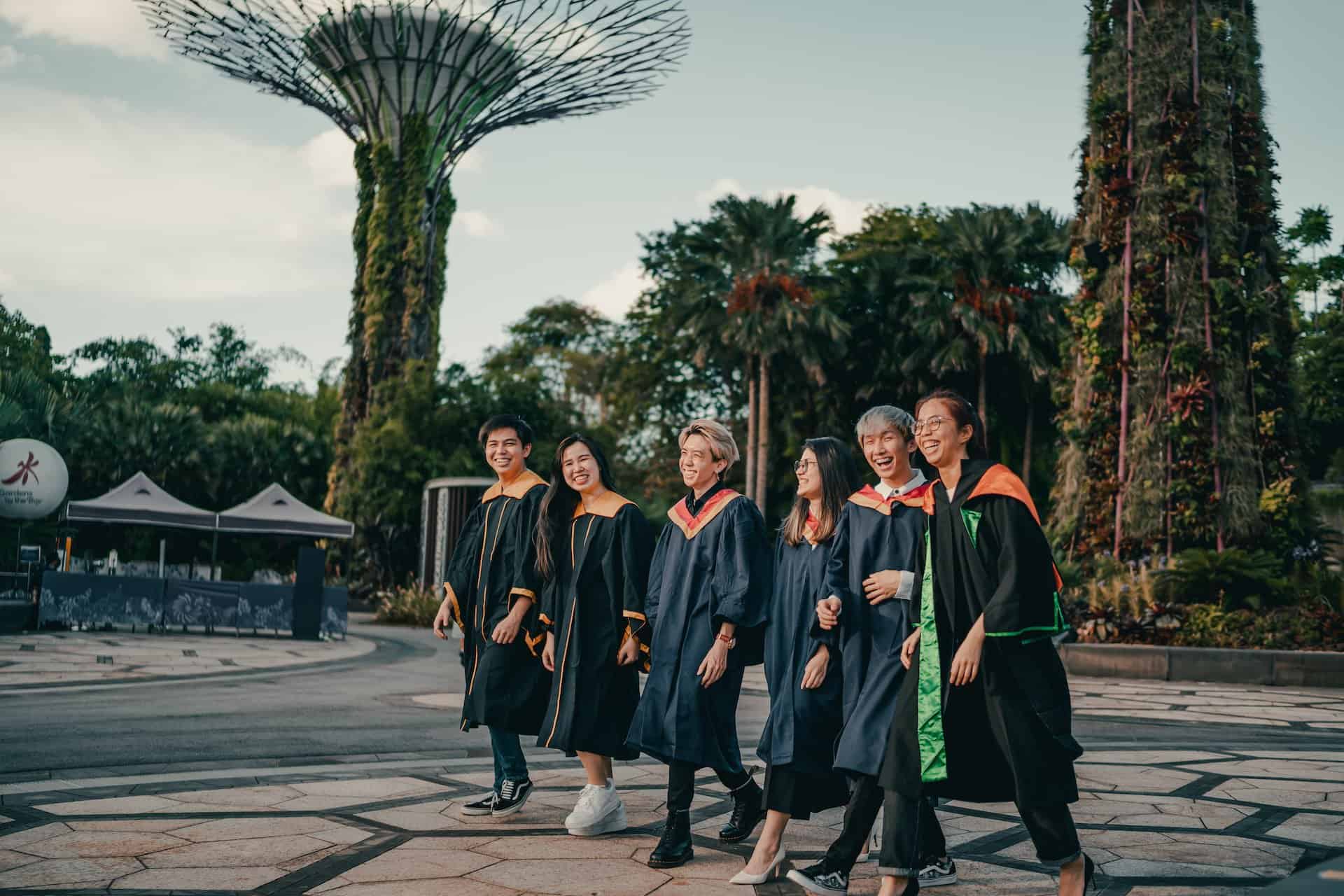 Group of friends in graduation robes smiling and laughing together