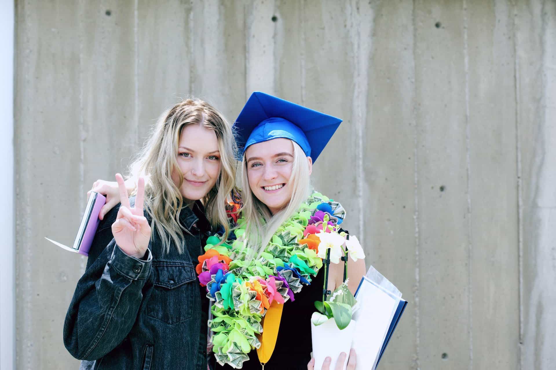 two friends posing for a picture, one is a graduate
