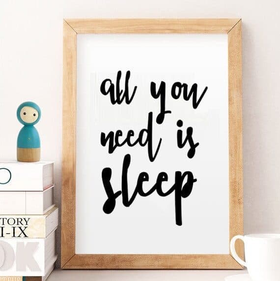 Wooden frame with white background with black font that says all you need is sleep.