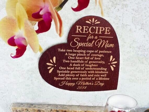 Wooden dark red heart sign with a recipe for a special mom. 