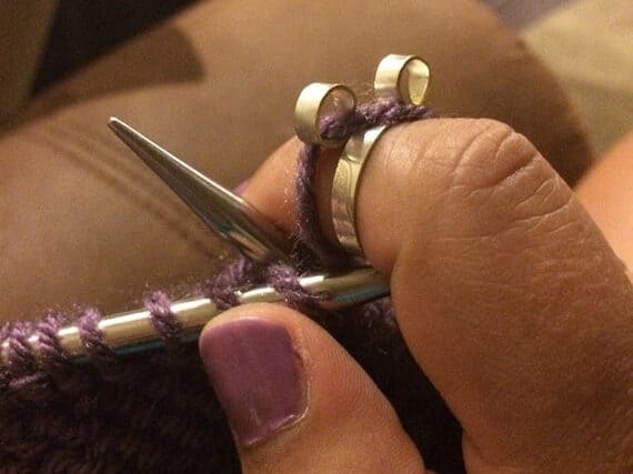 Close up of women's hands with a knitting ring on it.