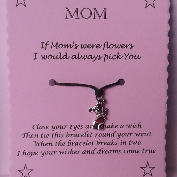 Purple paper with black font that says MOM If mom's were flowers I would always pick you. with a little girl holding flower silver charm on a black cord necklace, below more black font writing.